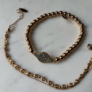Two Serafina gold bracelets evil eye and dainty crystal